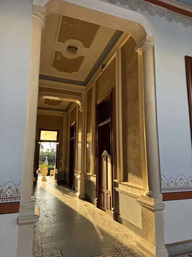 Pasillo central de Casona Cicero con columnas, puertas de madera y luz de la tarde