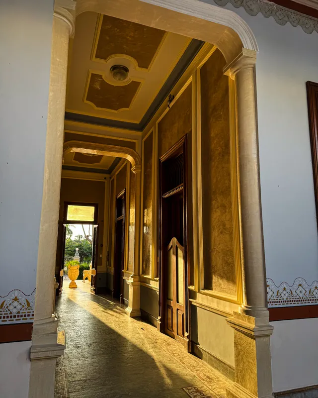 Colonnaded walkway bathed in golden afternoon light, opening to the garden