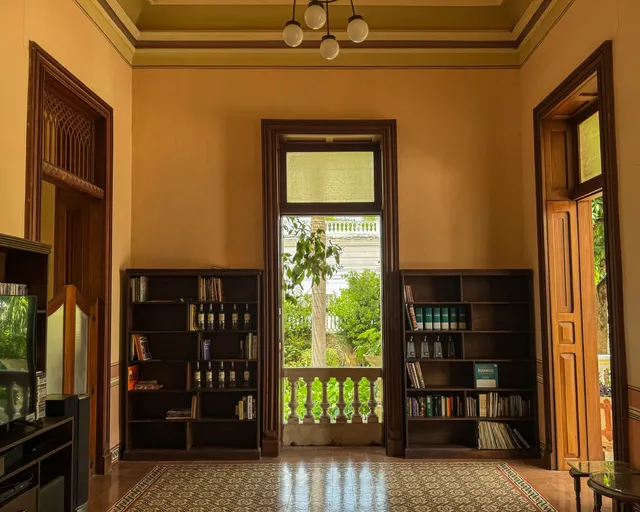 Library with two dark bookcases flanking a door to the garden, over patterned tile floors