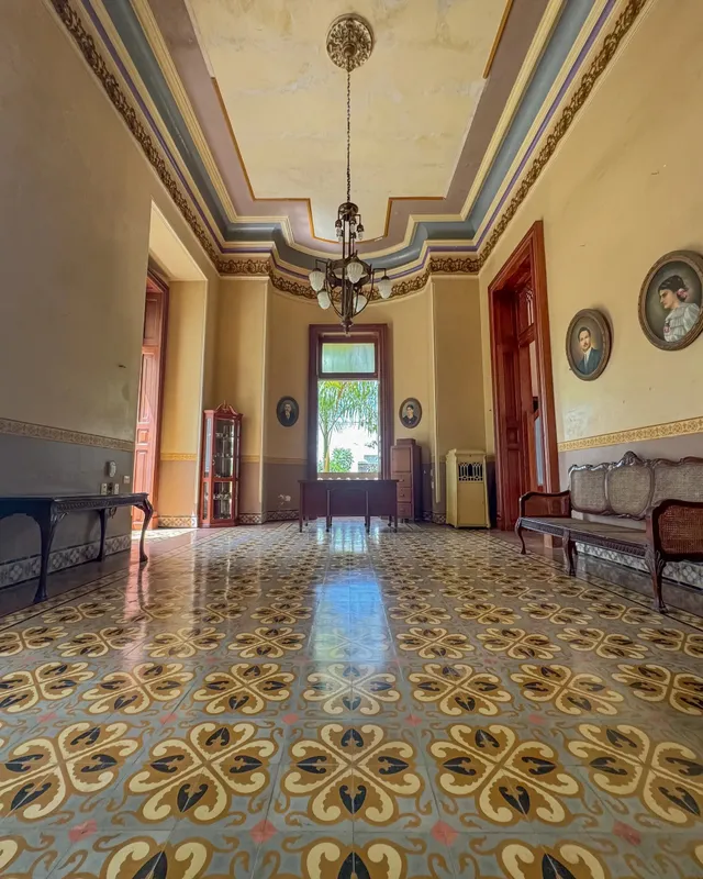 Drawing room with a chandelier, painted ceiling and patterned tile floor