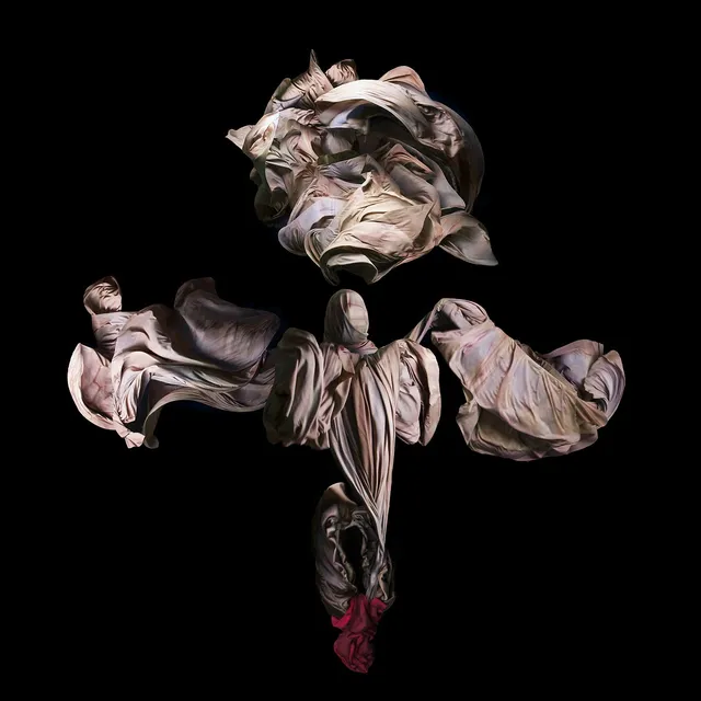 Performative photograph by Lizette Abraham: figure wrapped in sand-colored fabrics