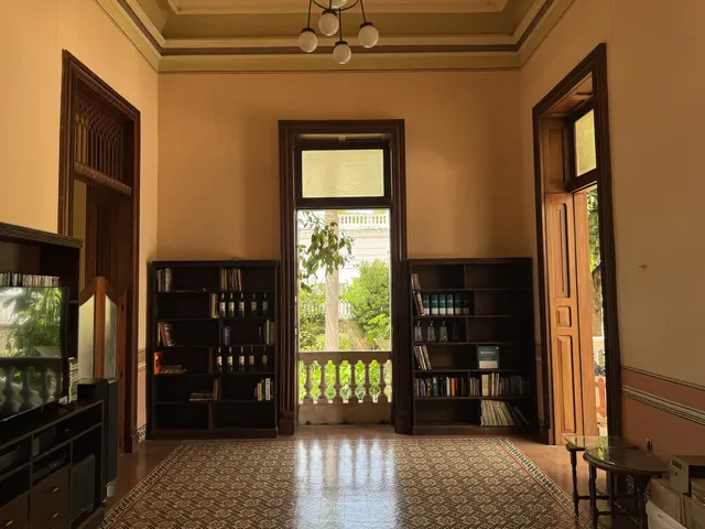 Biblioteca con libreros de madera, techo abovedado y piso de pasta