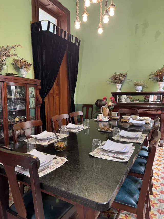 Comedor de la casa con techos altos y mesa larga bajo el candil