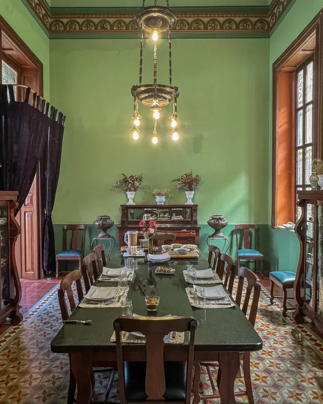 Comedor con mesa larga y candil, listo para una comida