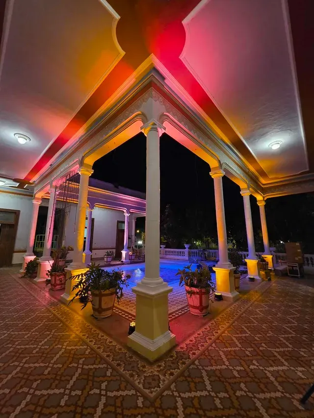 Central courtyard lit at night with pink and golden lights during an event