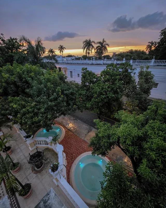 Aerial sunset view of the two circular jacuzzis among the garden trees