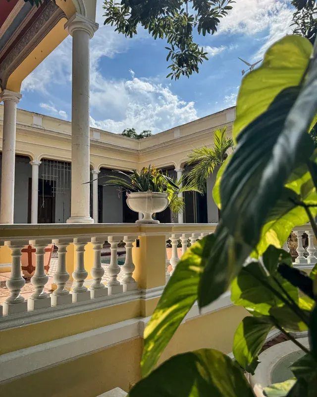 Column corridor and balustrade around the courtyard, with a potted palm