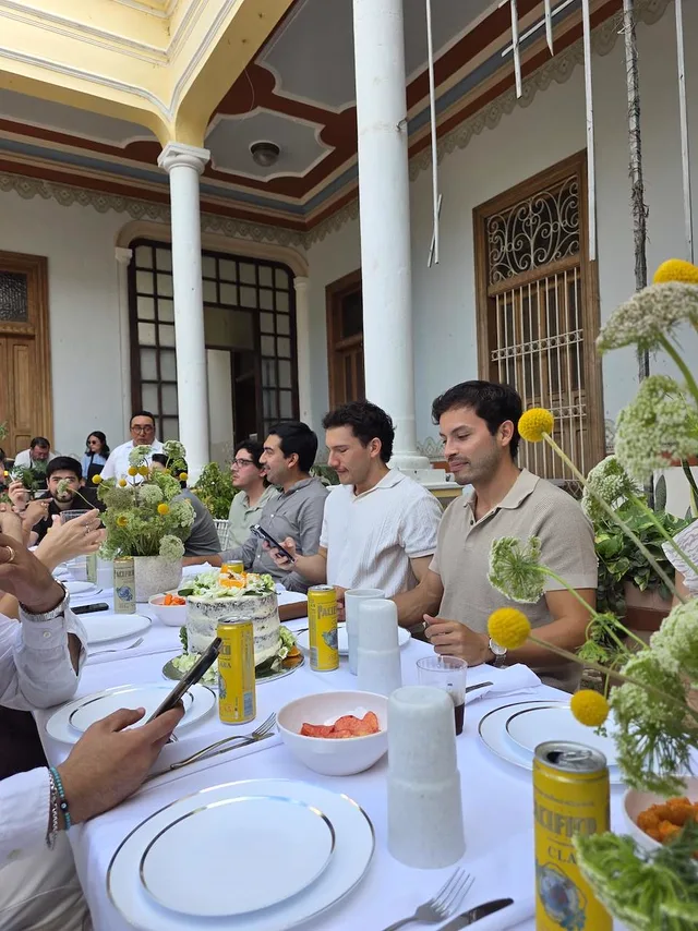 Invitados sentados a la mesa durante una comida en el corredor central