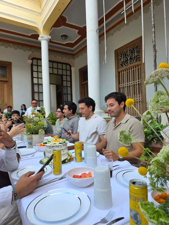 Invitados brindando en una mesa larga del corredor