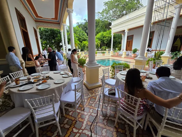 Invitados comiendo en mesas redondas en el corredor