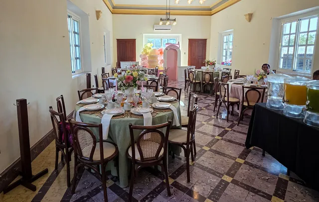 Salón de eventos con mesas redondas puestas