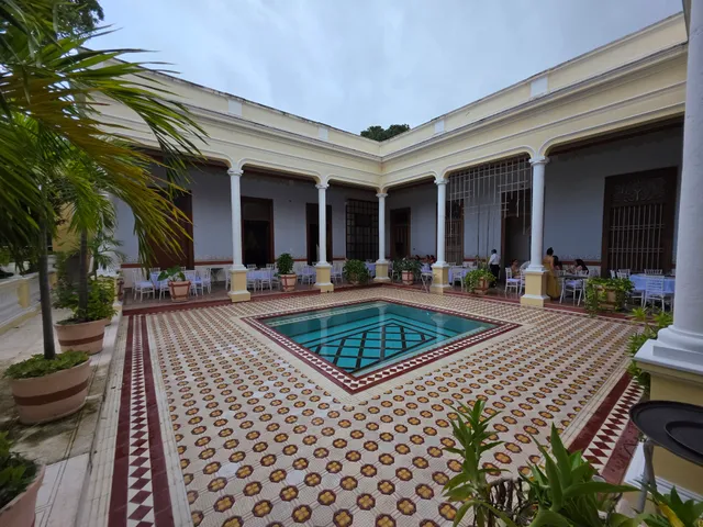 Patio central de día con la alberca y los corredores de columnas