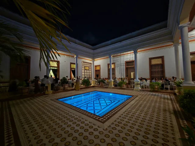 Patio central de noche con la alberca iluminada