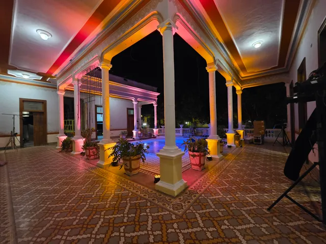 Patio central iluminado de noche con luces de colores entre las columnas