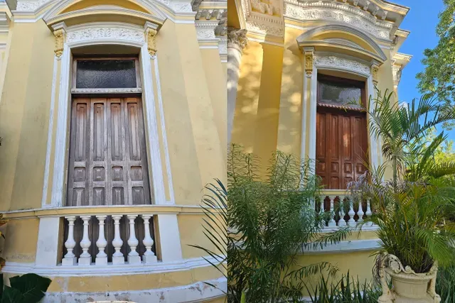 Antes y después de una puerta de madera en la fachada amarilla