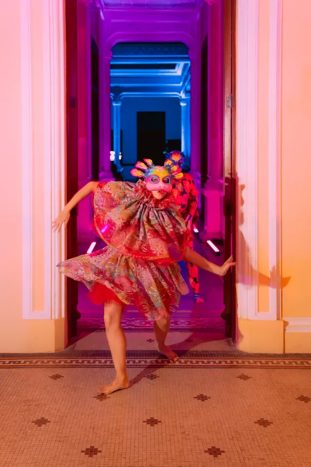 Bailarina con máscara y vestido de colores animando el pasillo