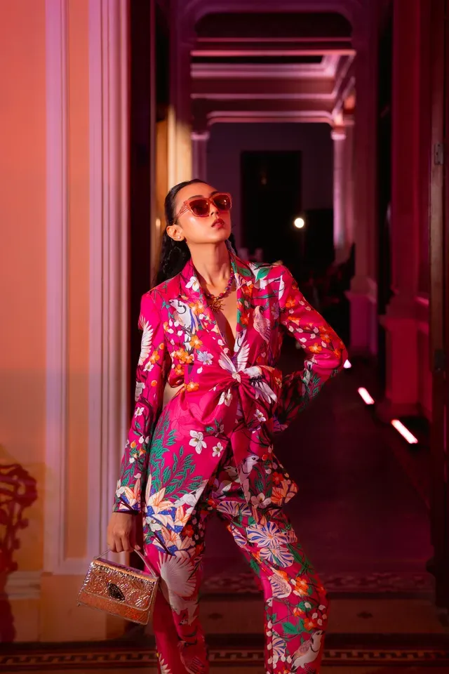 Modelo con traje floral rosa y lentes de sol
