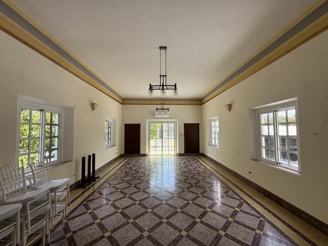 Salón de eventos con piso de mármol pulido y luz natural entrando por los ventanales